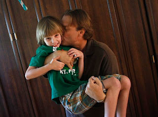 O pai de Jack o segura no colo e o beija. Foto de Joshua Lott, Agência Reuters.