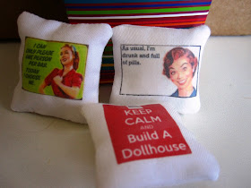 Three modern miniature cushions with funny slogans on them