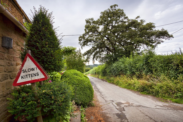 An amusing road sign in Great Tew in the Cotswolds by  Martyn Ferry Photography