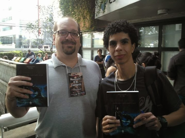 Foto do autor Mauricio R B Campos segurando o livro Sonhos Lúcidos ao lado do coautor Kléberson Arcanjo