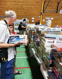 A man and a boy choosing model kits at a scale model show.