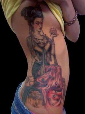 Geisha can be translated into ‘artist’; geishas themselves are seen as some of the most exotic, graceful, sensual and talented artists in the world; and although they are one of many remarkable symbols, geisha tattoos have become one of the most popular pieces in Asian influenced body art.  Many people like to use geisha tattoos that utilize the entire splendor of a traditional geisha or maiko (an apprentice whose appearance differs slightly from a full-fledged geisha). These are generally done in a portrait style, and depict the elegant figure with a porcelain-white complexion; small, brightly colored and bow-like lips; brilliantly hued kimono and one of the four shimada hairstyles (most commonly a style called ‘momoware,’ which looks something like a divided peach, and bears a good deal of colorful ornamentation).