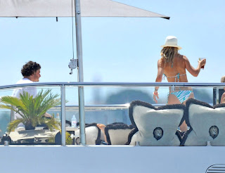 Kate Hudson wearing a blue and white bikini making a toast  on a Yacht in St. Tropez