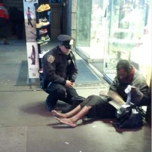 Policial doando botas para mendigo