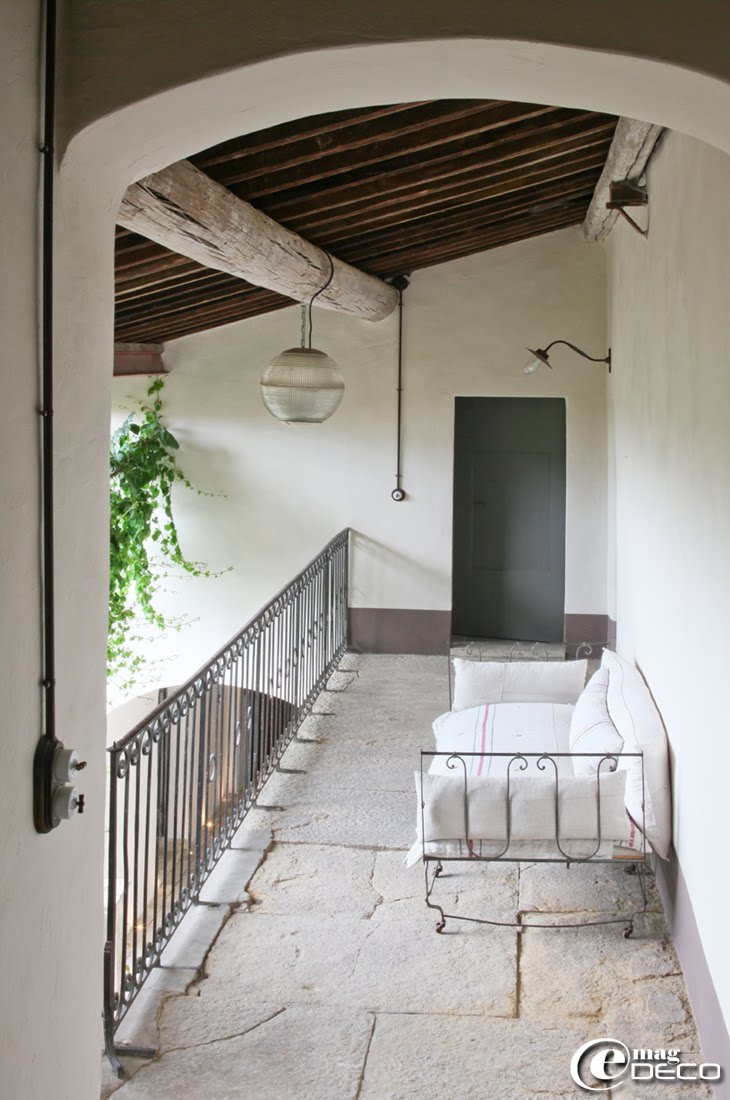 Dans la coursive de La Maison d'Ulysse, maison d'hôtes à Baron dans le Gard, un vieux lit d'enfant en fer se transforme en canapé