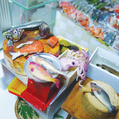 Fish being filleted on a miniature Hong Kong seafood stall.