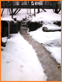 Long, shoveled out trail is formed of brownish slush with perfectly white snow on both sides.