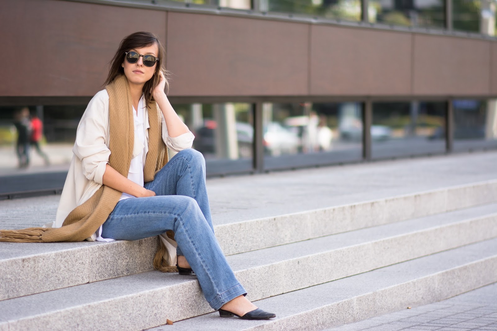 Fashion blogger street style outfit with trench oversize coat, big woolen camel scarf, white shirt and flare denim pants.