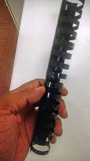 Photo of Marvin's hand holding a plastic binding comb.