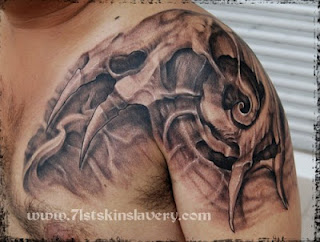 3d tattoo on the shoulder: alien-like bones