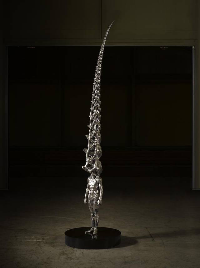 Karma is an intriguing sculptural installation by Korean artist Do Ho Suh that presents countless men sitting atop one another while shielding each other's eyes. Like his Cause & Effect piece, which features a spectacular tornado of figurines, Karma presents figurative sculptures ascending into the sky like a human ladder.
