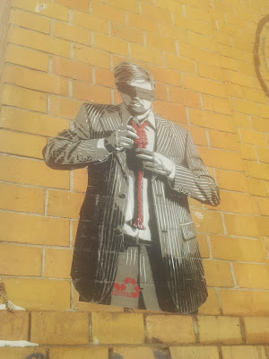 Street art piece of blind and tied man in Berlin