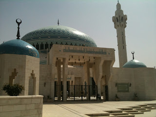 a large building with blue domes with Shah Mosque in the background