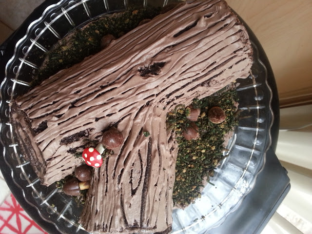 Log cake (Buche de Noel) with bark frosting, candy mushrooms, and edible moss