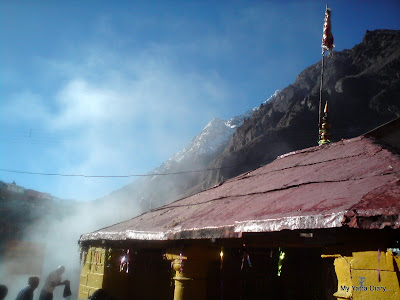 Fumes emanating from theTapt Kund with snow peaks in the 
background, Badrinath