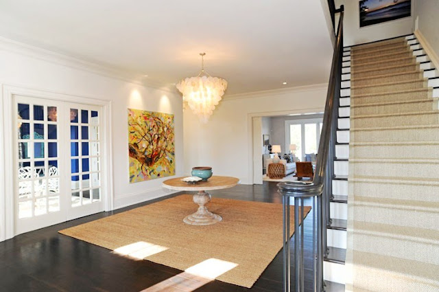 foyer with a staircase, dark wood floor, a round table, chandelier and french doors