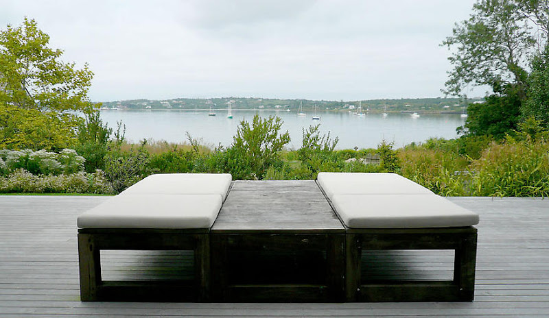 Modern lounge chairs on an outdoor patio overlooking a lake in Montauk on Long Island