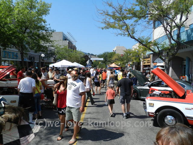 view of the street with the crowd of people looking at the cars of the show
