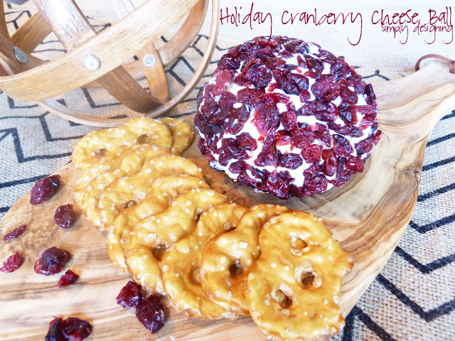 Cranberry Cheese Ball on a wood board with pretzel thins around it