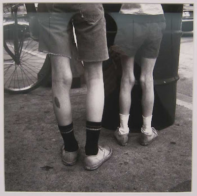 Photo of a man and woman wearing bermuda shorts, knobby leg with socks