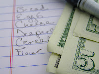 shopping list with money sitting on it