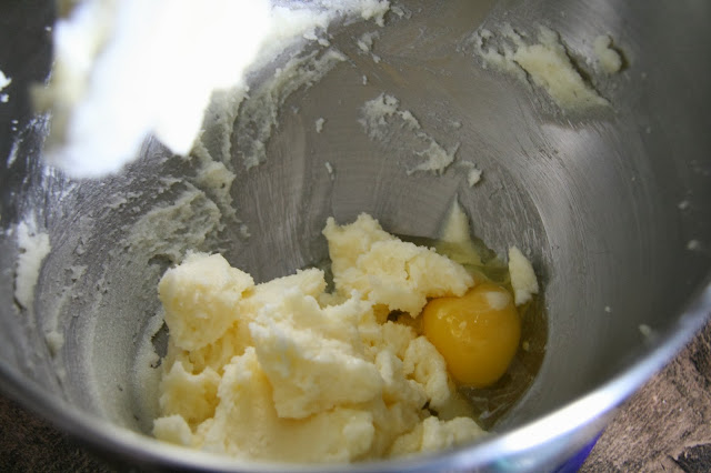 Inside the bowl of a stand-up mixer, add an egg with the creamed butter and sugar.