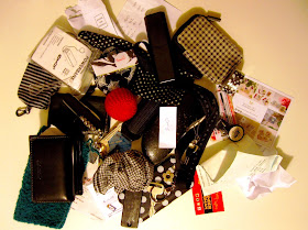 Large pile of items from a handbag including keys, hankie, wallet, various cases, business cards, scrunched up pieces of paper and a dolls' house miniature knitted pouffe and rug.