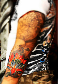 red lotus flower tattoo on the arm