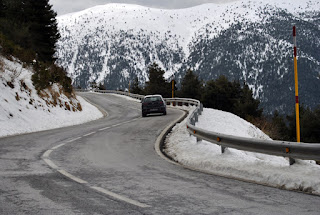 Coche circulando por carretera nevada