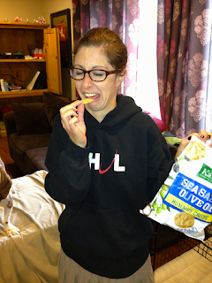 Woman making a grimacing face while trying to eat an unpleasant tasting chip