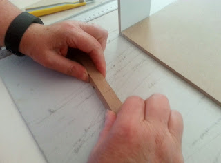 Person holding two pieces of broken dolls' house beam together.