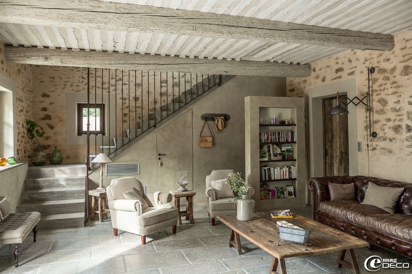 Dans le salon de la maison d'hôtes de charme, 'La Bergerie de Nano', table basse en bois sur tréteaux, canapé en cuir effet vieilli et fauteuils en lin naturel, le tout chez 'Flamant'. Porte en bois sur mesure, 'Portes Anciennes' à Saint-Rémy-de-Provence