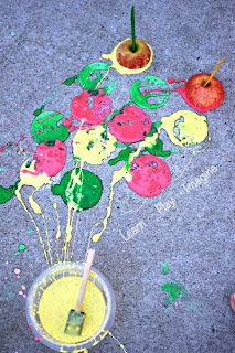 Sidewalk painting with apples, using homemade apple scented sidewalk chalk paint.  Kids will be delighted to make these apple prints ERUPT after painting!