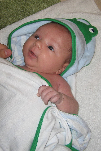 clean baby after a bath in a cute frog towel