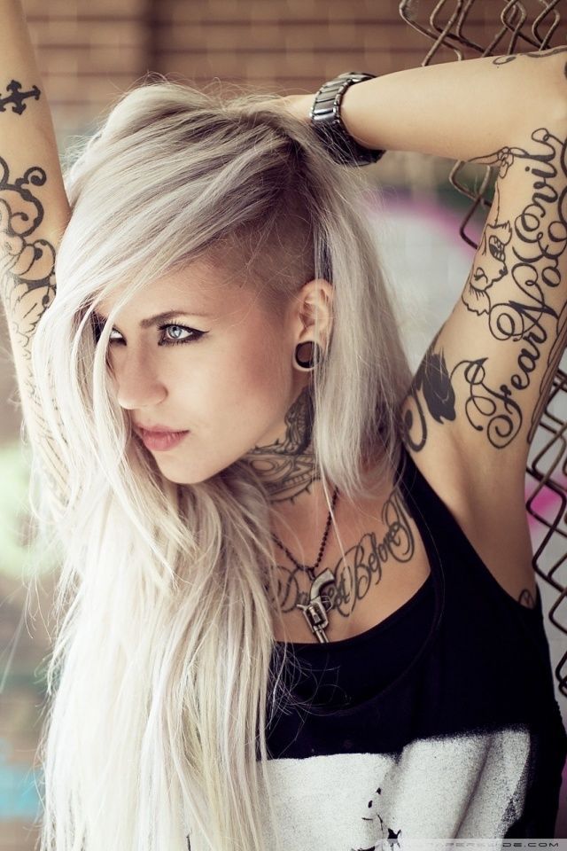Tatuajes de frases para chicas chica rubia de tipo gotica, lleva en los brazos tatuajes de letras y frases