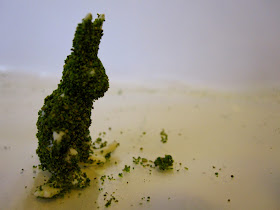 Plastic play farm rabbit., covered with green modelling flock with various bald patches.