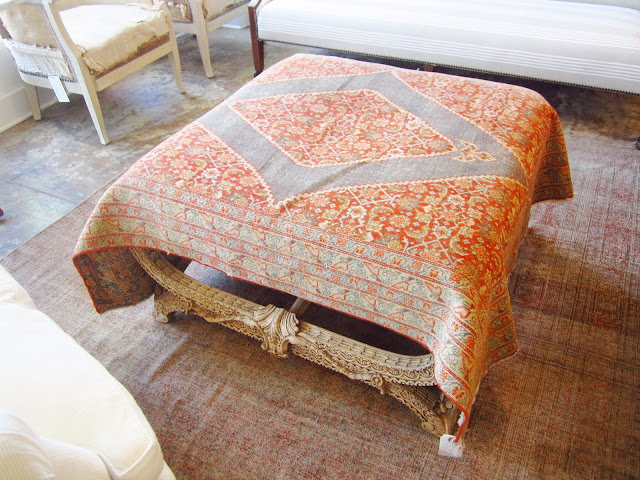 Vintage fabric is draped over a stunning carved ottoman
