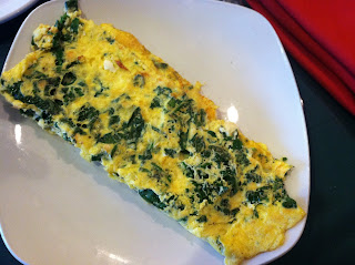 a plate of omelette with spinach on it