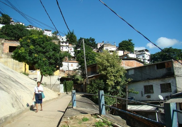 Dona Rosa caminha apressada numa das vielas do Morro da Coroa. "-Indo trabalhar, meu filho!" 