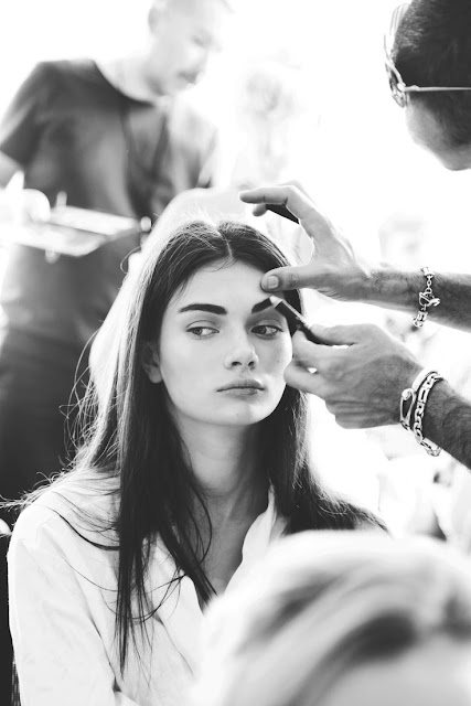 model getting her makeup done