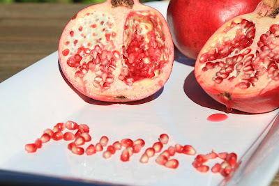 Punica Spelled Out with Pomegranate Seeds and A Split Pomegranate 