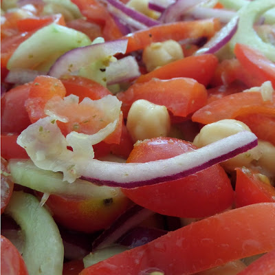 Greek Salad:  A fresh and delicious salad with tomatoes, cucumber, red onion, red bell pepper, and garbanzo beans tossed in a lemon and oregano dressing. 