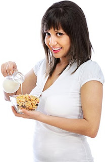 Smiling Brunette Pouring Milk on Cereal smiling-brunette-pouring-milk-on-cereal