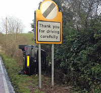 crashed car in ditch with safety sign fail