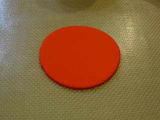 red fondant circle cutout on baking mat