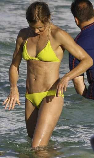 A brawny Cameron Diaz emerges from the Miami sea in a yellow bikini