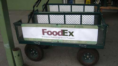 Green garden cart with a sign on the side that says FoodEx, mimicing the FederalEx logo