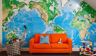 sala com sofá laranja e um grande mapa mundi na parede. sala com sofá laranja e um grande mapa mundi na parede.