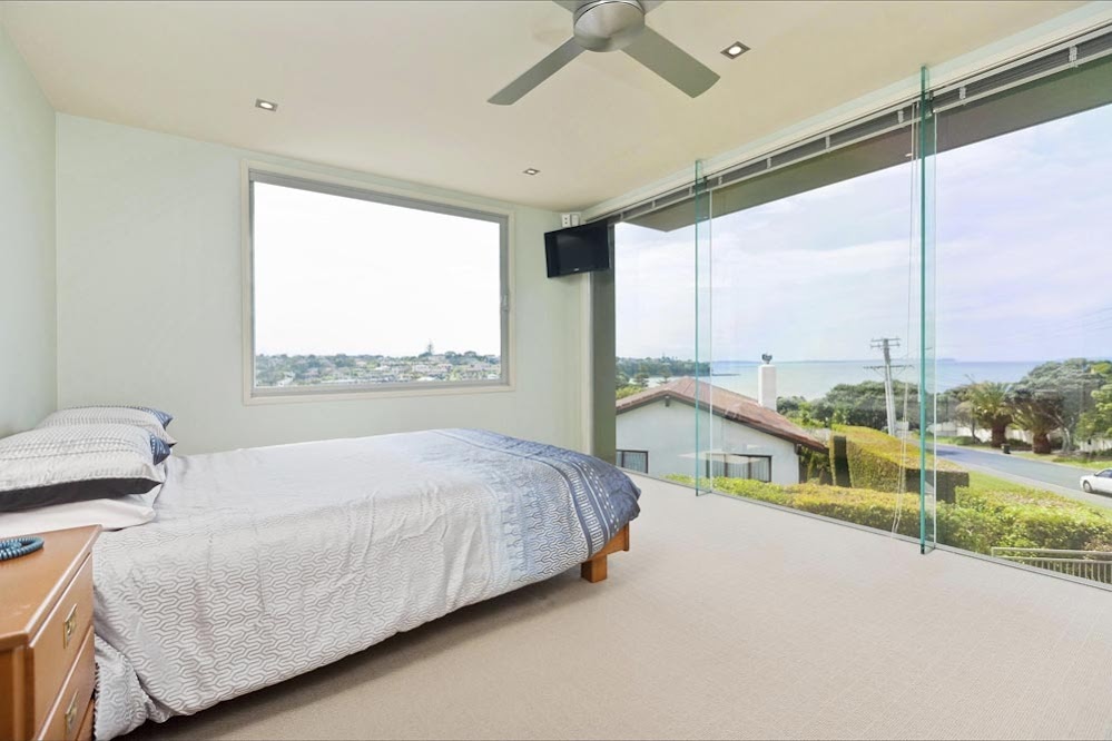 Photo of one of the bedrooms with glass wall facing the street