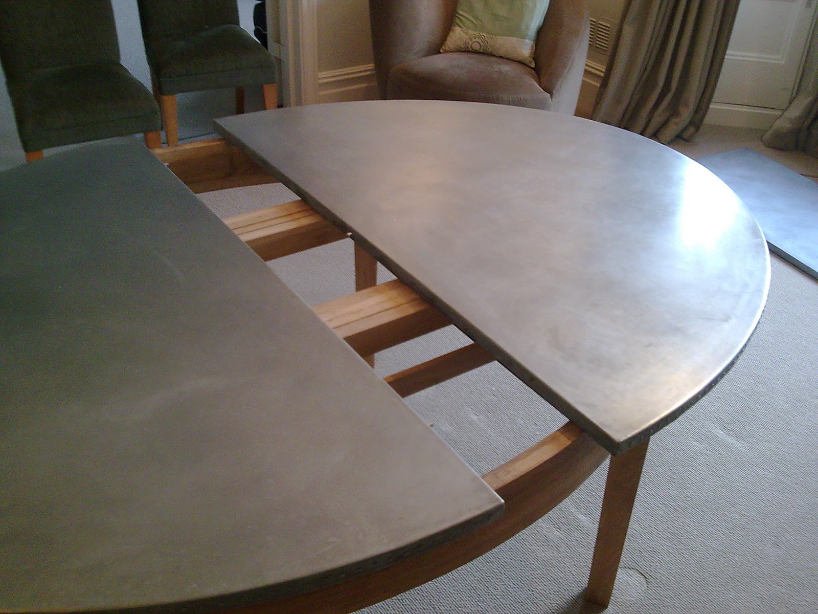 Deballage Designs Oval oak table with a studded zinc top